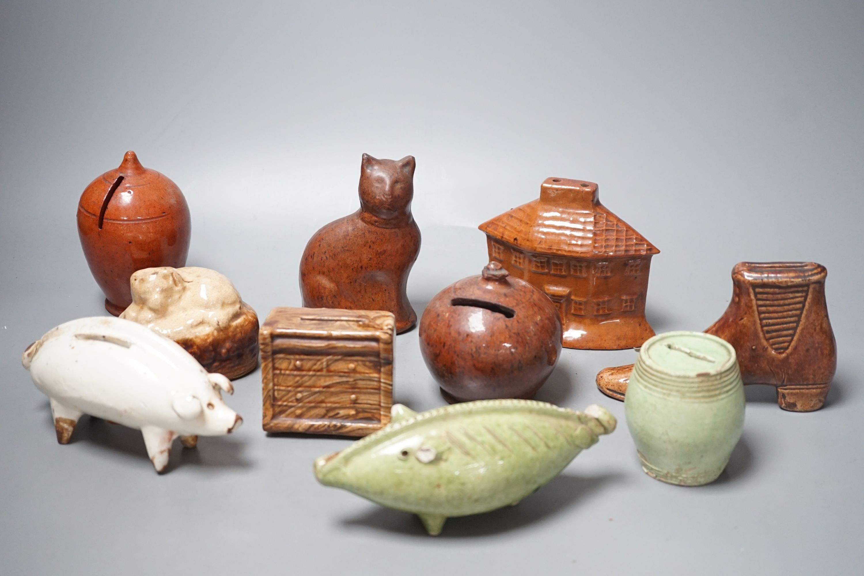 A collection of ten, 19th century Dutch and British pottery money boxes - tallest cat money box 12 cms high